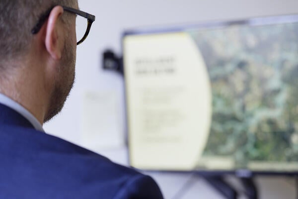 Over the shoulder of professor looking at a flood map on their computer screen