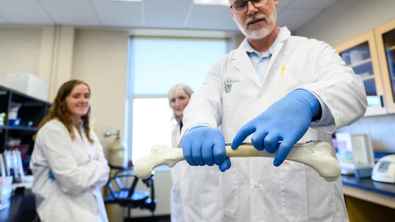 Dr. Thomas Willett pointing to a section of a femur bone