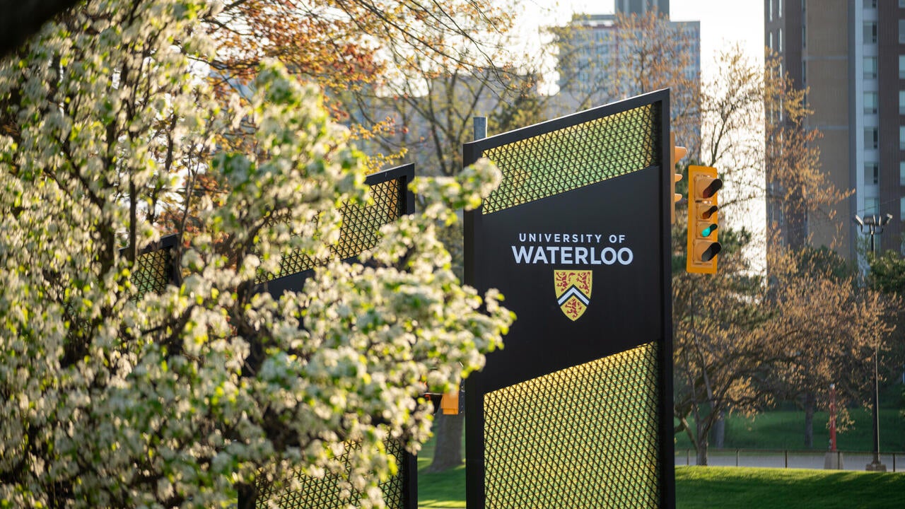 University of Waterloo signage behind spring flowers