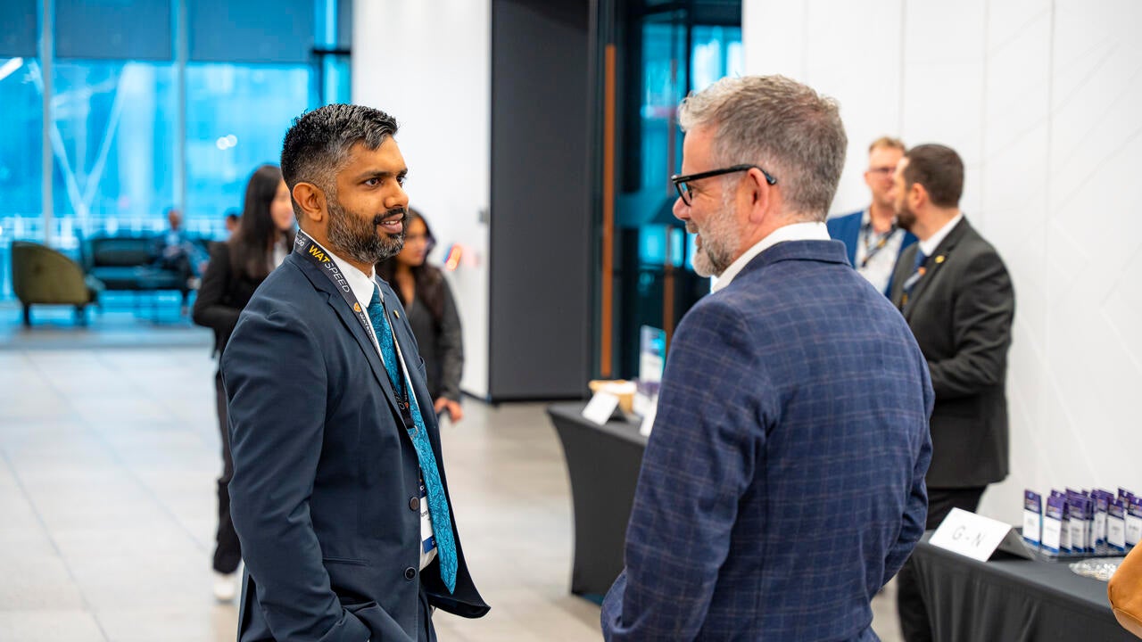Aaron Pereira in mid-conversation with a man
