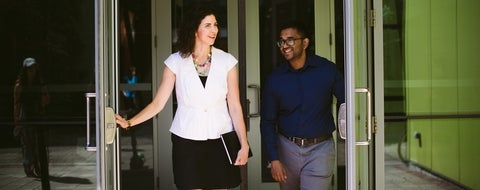 Two people walking through a door