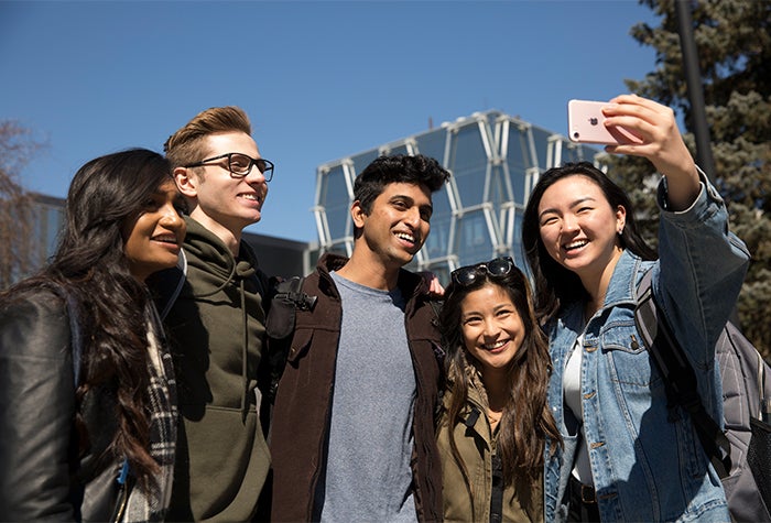students gathered for a selfie photo on campus