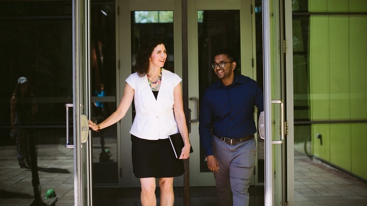 Two employees leaving a building