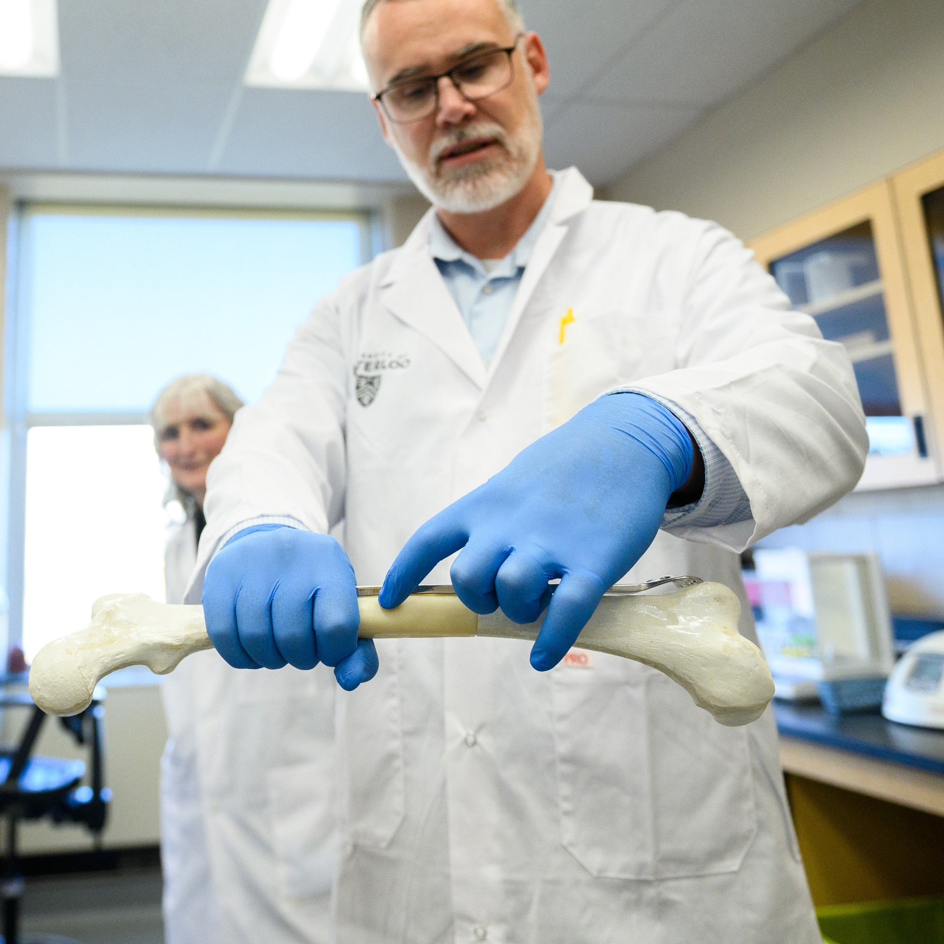 Dr. Thomas Willett holding a bone in his hands