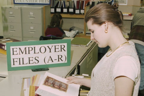 Woman sitting in the co-op office looking through employer files