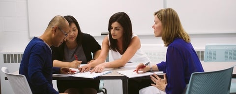 Four people around a table in a learning and development workshop