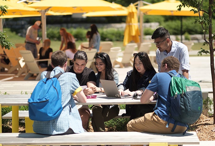 friends sitting together outside on a picnic table