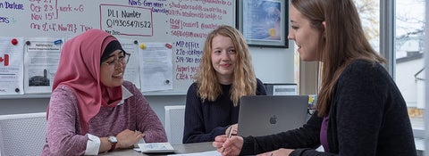 Two students at desk with an advisor at the University of Waterloo