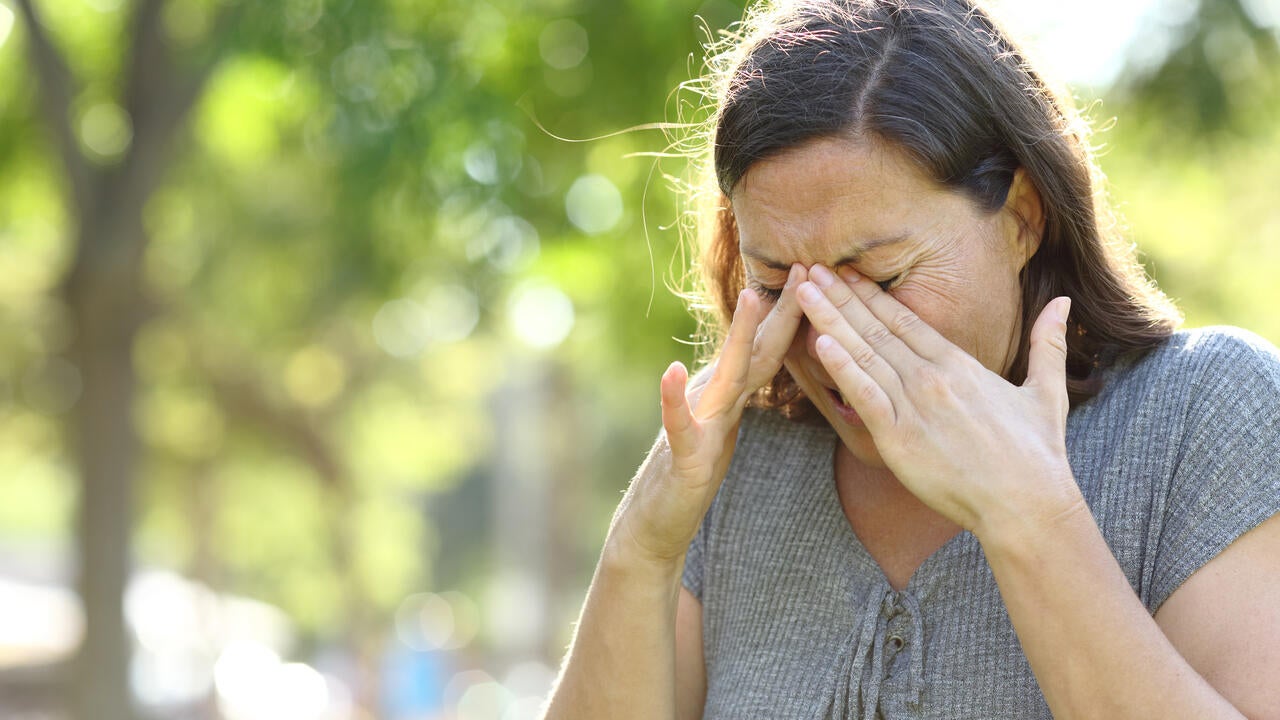 Woman rubs eyes with her hands