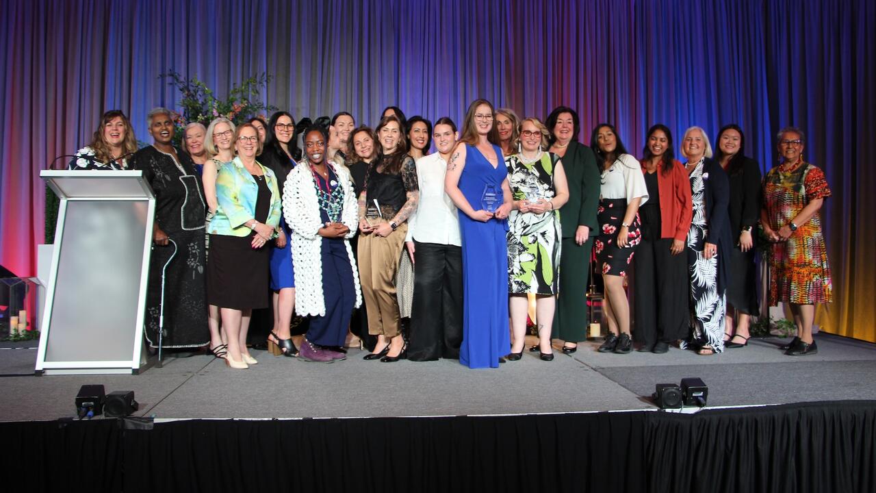 Award winners standing on stage with their awards