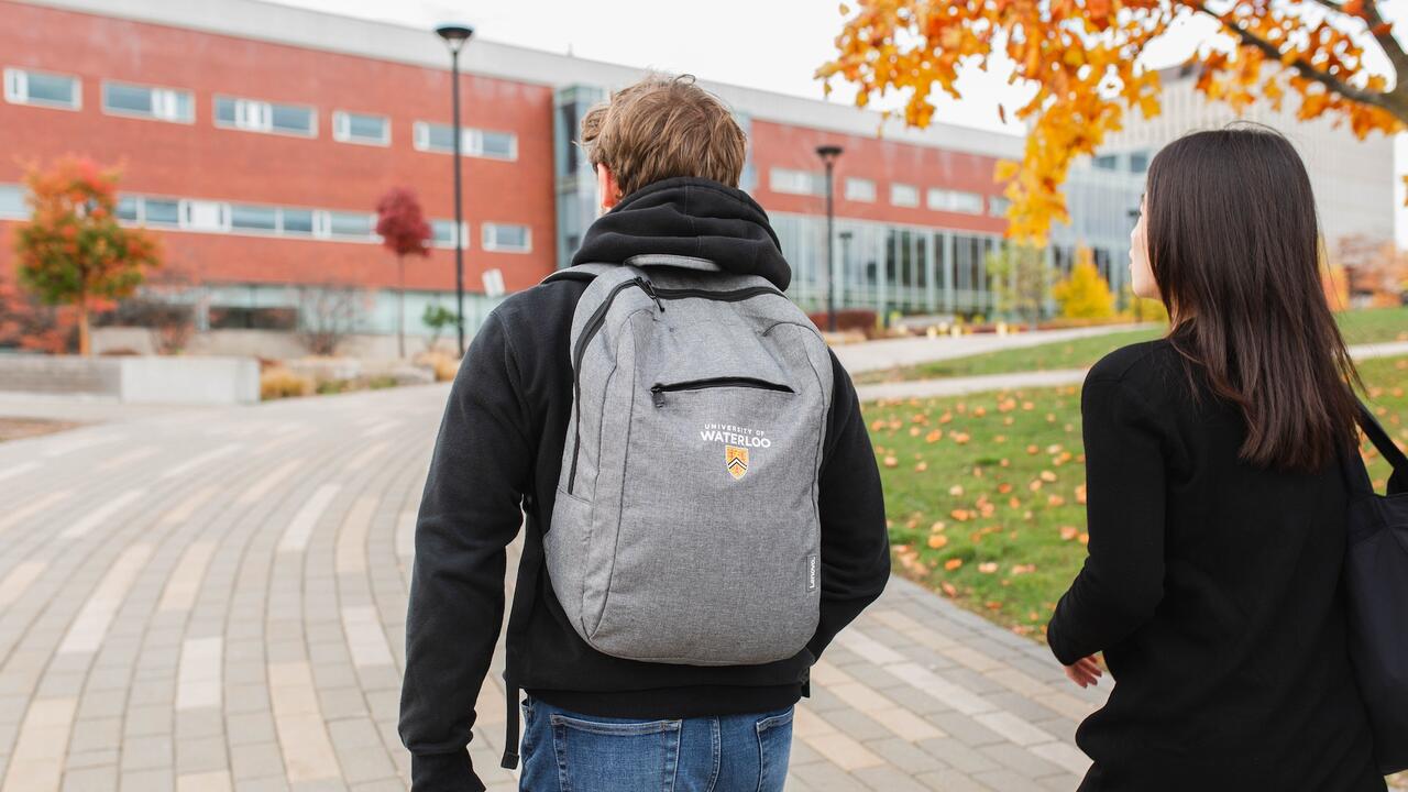Two students walking towards a building on campus