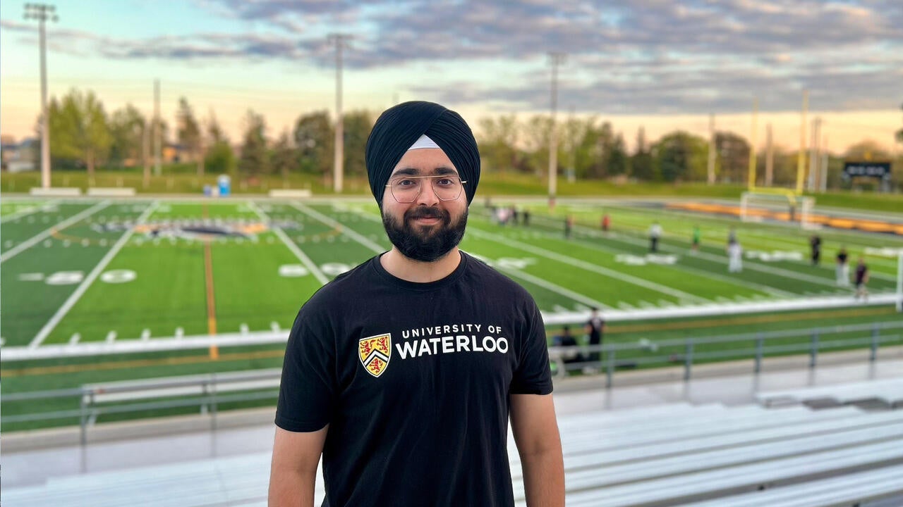 Sehaj in the bleachers overlooking a football field