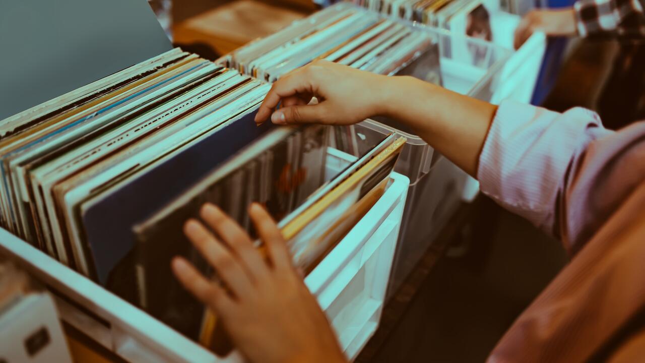 A woman's hands browsing through a bin of records