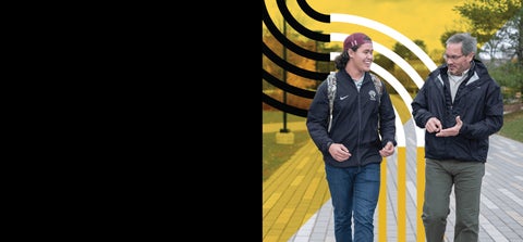 A parent and student walk along a path chatting