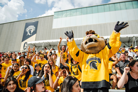 Crowd of students waving during a football game